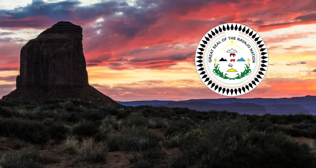 Navajo Nation land at sunset shown with the Great Seal of the Navajo Nation.
